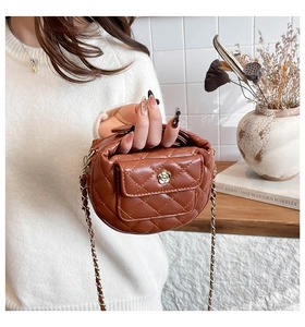 Detail of dark brown quilted bag featuring golden flower turn-lock and chain strap