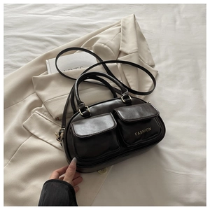 Detailed view of leather bowling bag with gold buckles and dual front pockets