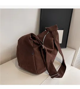 Detail of dark brown large canvas hobo bag with silver zipper and wide adjustable strap