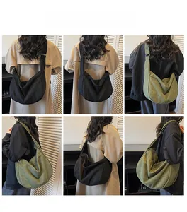 Detail view of large canvas crescent crossbody bag in black and olive green colors