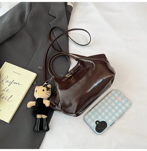 Deep brown oil wax leather crossbody bag detail with cute cat plush charm decor