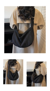 Detail of a black crescent hobo bag showing soft canvas texture and spacious interior