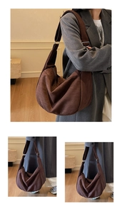 Detail of adjustable metal buckle on dark brown suede shoulder bag in minimalist setting