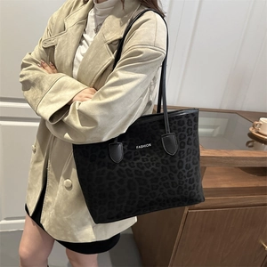 Grand sac cabas à imprimé léopard noir avec texte Fashion porté par un mannequin élégant