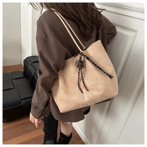 Khaki frosted suede tote bag with woven rope detail shown on a model's shoulder