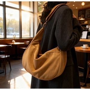 Urban chic large brown suede crescent tote bag shown on model in warm afternoon light