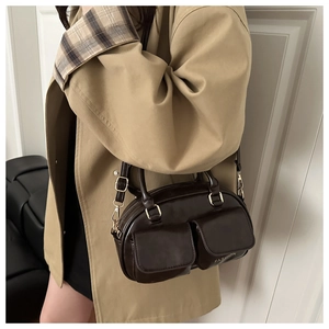 Detail of vintage chocolate brown leather Boston bag featuring dual front flap pockets