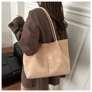 Detail of a large beige faux suede tote bag showing soft texture and spacious slouchy design