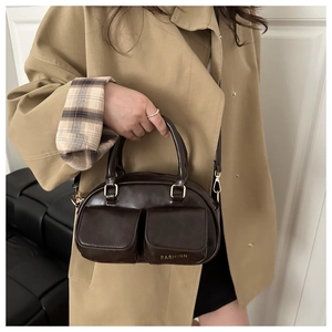 Close-up of vintage brown leather pillow bag featuring dual pockets and fashion lettering