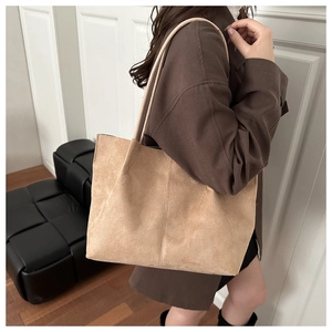 Close-up of suede texture and vertical stitching detail on large khaki tote bag