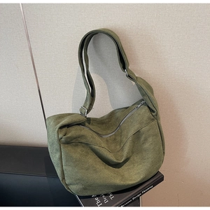 Detail of olive green suede messenger bag with silver buckle and wide strap