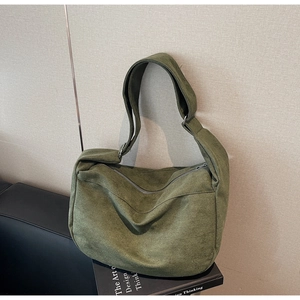 Detail view of large olive green suede hobo bag with smooth silver zipper and wide strap