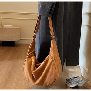 Detail of brown suede hobo bag with wide shoulder strap and silver metal hardware