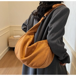 Caramel suede tote bag detail showing soft texture and slouchy drape on model