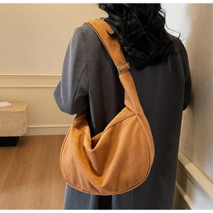 Close-up of caramel suede hobo bag featuring wide strap and silver buckle detail