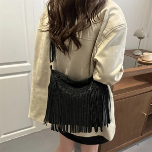 Fashionable black tassel shoulder bag with leopard texture on a female model indoors