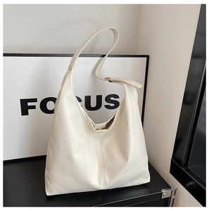 Detail of adjustable strap and gold hardware on cream minimalist hobo shoulder bag