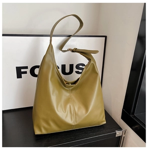 Detail shot of an olive green faux leather tote bag showing fine grain and soft texture