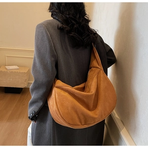 Close-up of caramel brown suede hobo bag showing minimalist style and soft texture