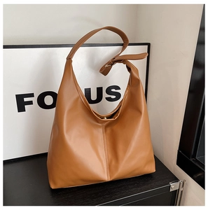 Close-up of brown PU leather hobo bag with adjustable wide shoulder strap and metal buckle