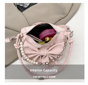 Capacità interna della borsa rosa con fiocco contenente rossetto e cipria