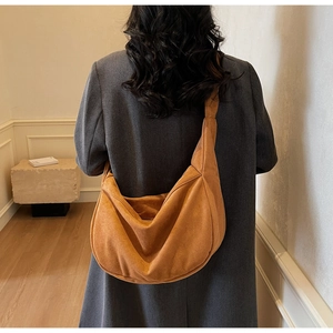 Detail of large brown suede hobo bag with natural folds and minimalist shoulder strap