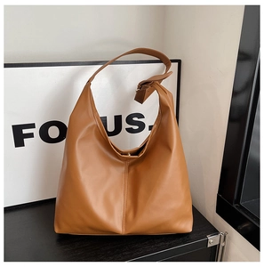 Detail view of large caramel brown PU leather tote bag with adjustable wide shoulder strap