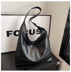 Detail view of large black matte tote bag with wide strap and minimalist middle seam