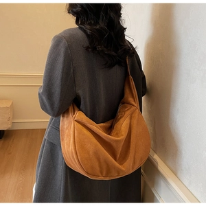 Detail of caramel suede hobo bag with large capacity and smooth zipper on model
