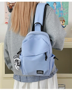 Détail du sac à bandoulière en nylon bleu clair avec plis et breloque chaussure