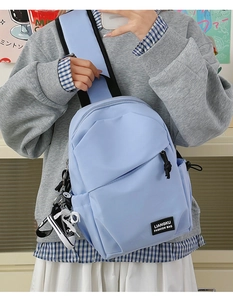 Détail du sac bandoulière bleu clair imperméable en nylon avec pendentif chaussure et patch