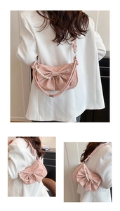 Sac bandoulière rose satiné avec nœud et perles porté sur une veste de blazer blanche