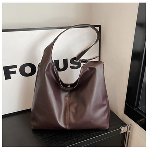 Detail of matte leather hobo bag in deep burgundy with visible vertical stitching