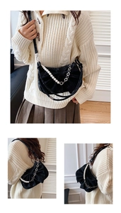Détails du sac noir à nœud avec bandoulière en perles et éléments en trèfle