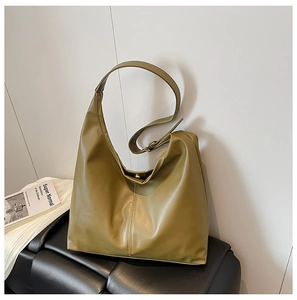 Detail of olive green tote bag showing pebbled leather texture and adjustable strap buckle