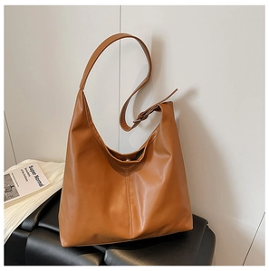 Detail of caramel brown hobo bag with vertical stitching and adjustable wide shoulder strap