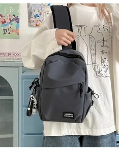 Détail du sac à bandoulière imperméable gris foncé avec poche latérale et logo de marque