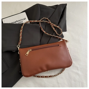 Close-up of brown litchi pattern leather shoulder bag with gold chain and back zipper pocket