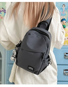 Détail du sac de poitrine en nylon gris foncé avec charme basket et fermetures