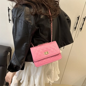 Pink quilted leather crossbody bag with gold chain strap shown on model's shoulder