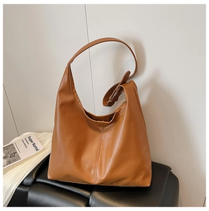 Detail of a brown matte PU leather tote bag featuring a vertical stitched center seam