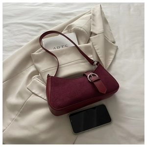 Detailed close-up of burgundy suede shoulder bag with elegant silver ring buckle detail