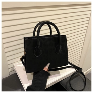 Detail of black leopard embossed square handbag with round handle and matte finish