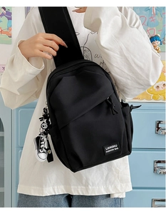 Vue détaillée du sac bandoulière en nylon noir avec breloque décorative mini basket