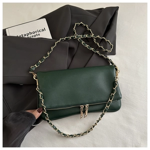 Detail of dark green lychee pattern leather flap bag with gold chain strap and dual zippers