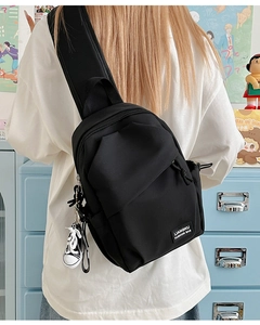 Vue détaillée arrière d'un sac de poitrine noir avec bandoulière et pendentif chaussure