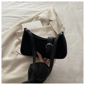Detail of black matte leather crescent bag featuring silver buckle and slim shoulder strap