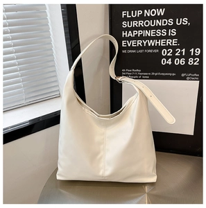 Close-up of cream-colored tote bag with adjustable shoulder strap and vertical stitching