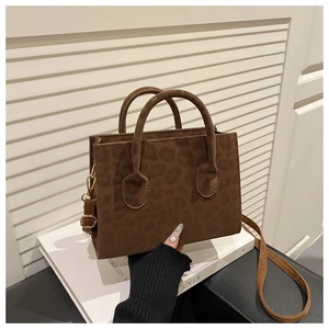 Detail of leopard print handbag with golden hardware and adjustable crossbody strap