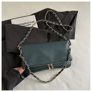 Detail of dark green lychee pattern faux leather bag with gold chain strap and dual zippers